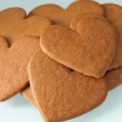 Stos ciastek korzennych w kształcie serc, idealnych na walentynki lub jako słodki gest.