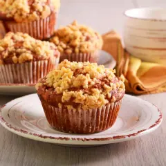Pyszne muffinki drożdżowe z kruszonką na talerzykach, obok filiżanka kawy.