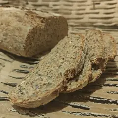 Wilgotny chleb orkiszowy, pokrojony w kromki, z widocznymi ziarnami. Idealny na śniadanie.
