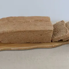 Chleb graham na drewnianej desce, pokrojony na kromki. Idealny na zdrowe śniadanie.