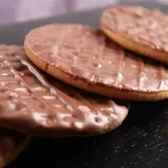 Czekoladowe ciastka digestive ułożone na czarnym tle. Idealne na popołudniową herbatę.