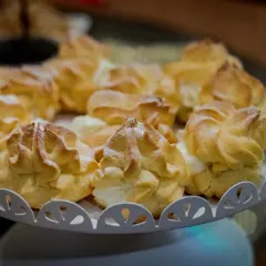 Pyszne ptysie z kremem, posypane cukrem pudrem. Idealne na deser, gdy masz ochotę na coś słodkiego.