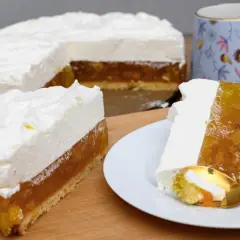 Puszysty krem ze śmietany 30 na biszkopcie z galaretką owocową. Na talerzyku porcja ciasta z widelczykiem.