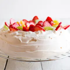 Puszysta masa do pavlovej ozdobiona truskawkami, kiwi i pomarańczą.