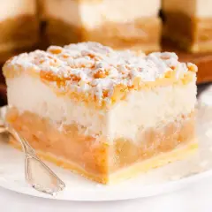 Puszysta piana do szarlotki, z jabłkami i kruszonką, posypana cukrem pudrem. Idealna na deser.