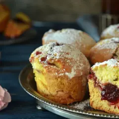 Puszyste muffinki z dżemem, posypane cukrem pudrem, kuszą swoim domowym wyglądem.