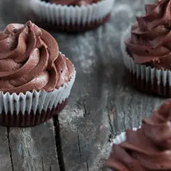 Kilka pysznych muffinek z kremem czekoladowym, ułożonych na drewnianym blacie.