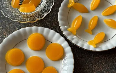 Pomarańczowa żelka do tortu w kształcie rybek i kółek.