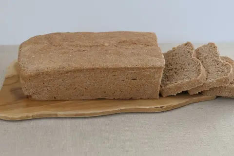 Chleb graham na drewnianej desce, pokrojony na kromki. Idealny na zdrowe śniadanie.