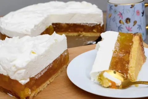 Puszysty krem ze śmietany 30 na biszkopcie z galaretką owocową. Na talerzyku porcja ciasta z widelczykiem.