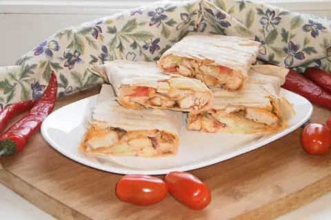 Pyszny lawasz z warzywami i kurczakiem, podany z papryczkami chili i pomidorkami.