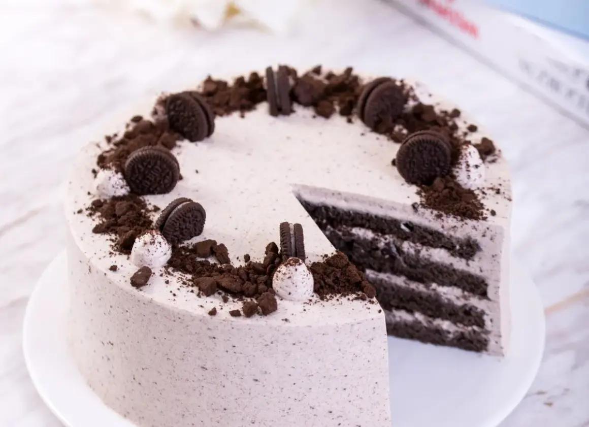 Pyszny krem oreo z czym łączyć? Z ciastem czekoladowym i bitą śmietaną, udekorowany pokruszonymi ciasteczkami.