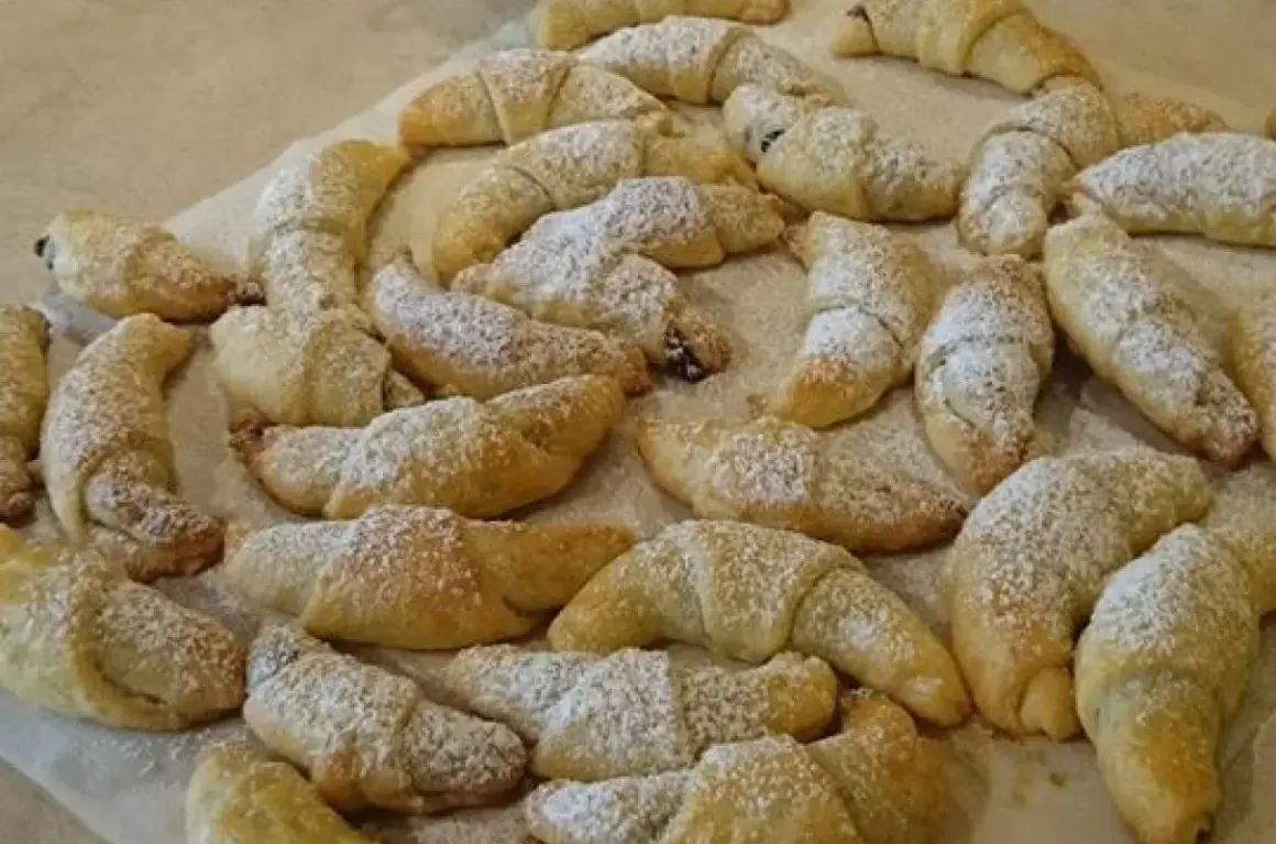 Mnóstwo pysznych, domowych rogalików z powidłami, posypanych cukrem pudrem. Idealne na deser lub do kawy.