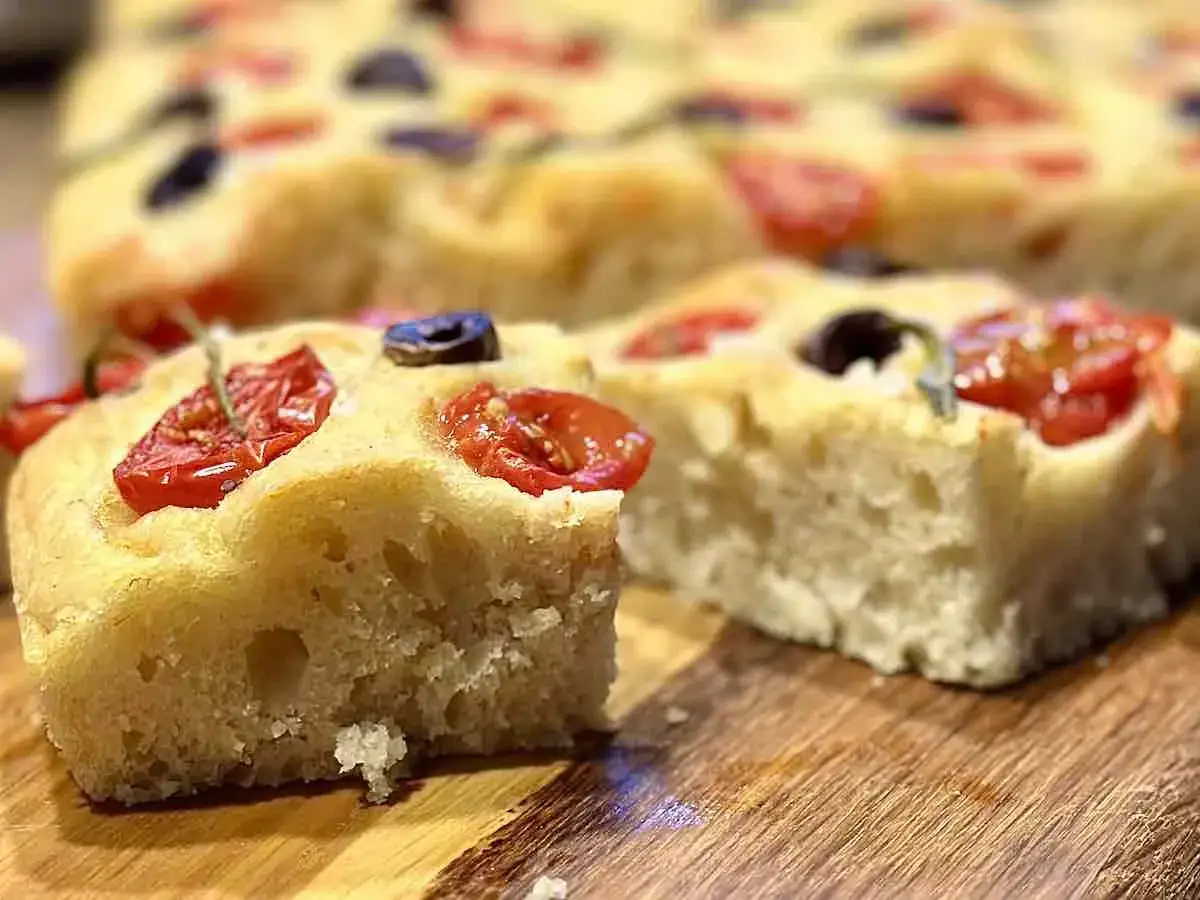 Pyszna focaccia z pomidorkami i oliwkami, idealna na przekąskę. Ten przepis na focaccię jest prosty i szybki.