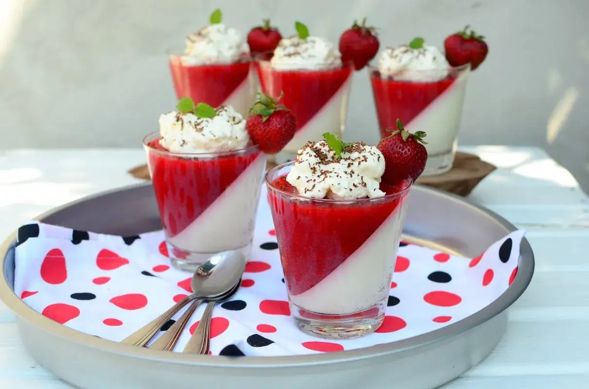 Pyszna panacotta w pucharku przepis. Deser z musem truskawkowym, bitą śmietaną i świeżymi owocami.
