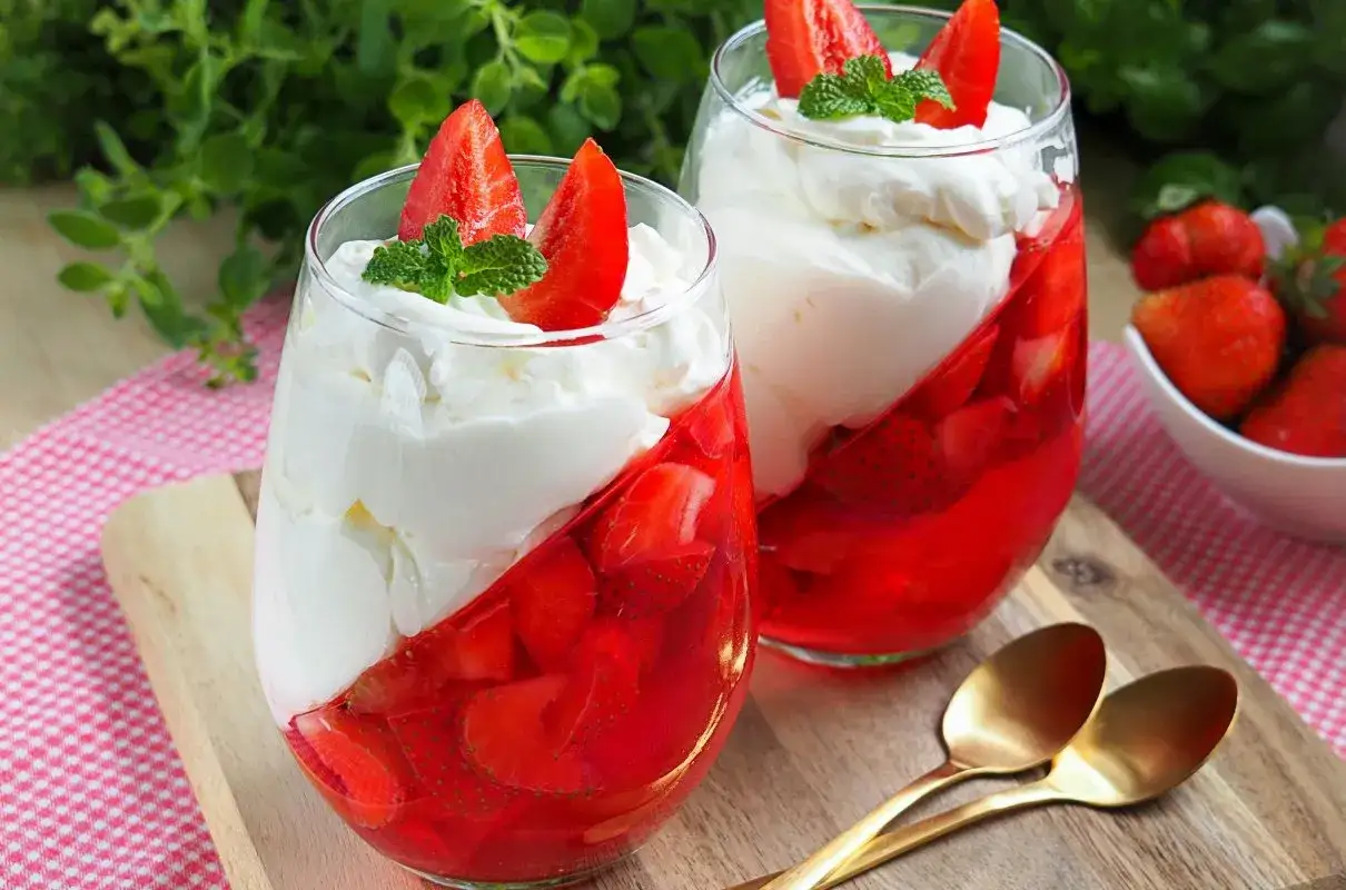 Pyszne desery z galaretką truskawkową i bitą śmietaną. Idealne owoce do masy mascarpone to właśnie truskawki.