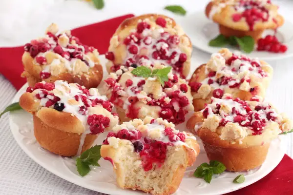 Pyszne babeczki drożdżowe z malinami i kruszonką, polane lukrem. Idealne na deser!